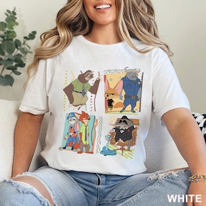 May include: White t-shirt with a cartoon design featuring characters from the film Zootropolis. The design includes a sloth, a fox, a buffalo, a rabbit, a fox, and a raccoon. The word "WHITE" is printed at the bottom right.