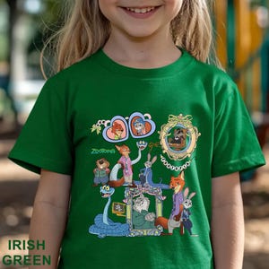 May include: Irish green t-shirt featuring a colorful graphic of characters from the animated movie Zootopia. The design includes various animal characters in frames and the word "Zootopia". The shirt also has the words "Irish Green" at the bottom.