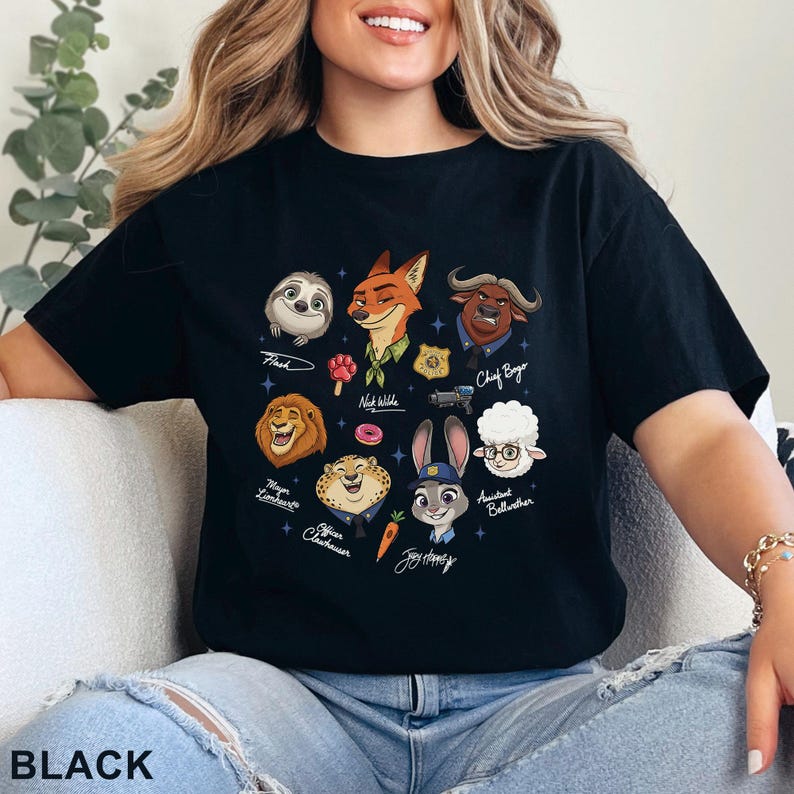Puede incluir: Una camiseta negra de manga corta con un estampado gr&aacute;fico de varios personajes animales animados, incluyendo un zorro, conejo, perezoso, le&oacute;n, guepardo, oveja y b&uacute;falo, junto con peque&ntilde;os iconos como una zanahoria, rosquilla y placa.