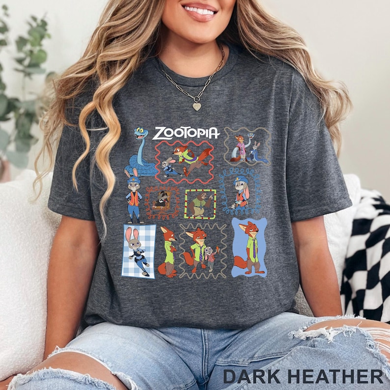 K&ouml;nnte beinhalten: Ein dunkelgrau meliertes Kurzarm-T-Shirt mit einem Grafikdruck verschiedener Zootopia-Figuren in bunten Rahmen. Das Design zeigt Judy Hopps und Nick Wilde in verschiedenen Posen, mit dem Zootopia-Logo in wei&szlig;em Druck am oberen Rand.