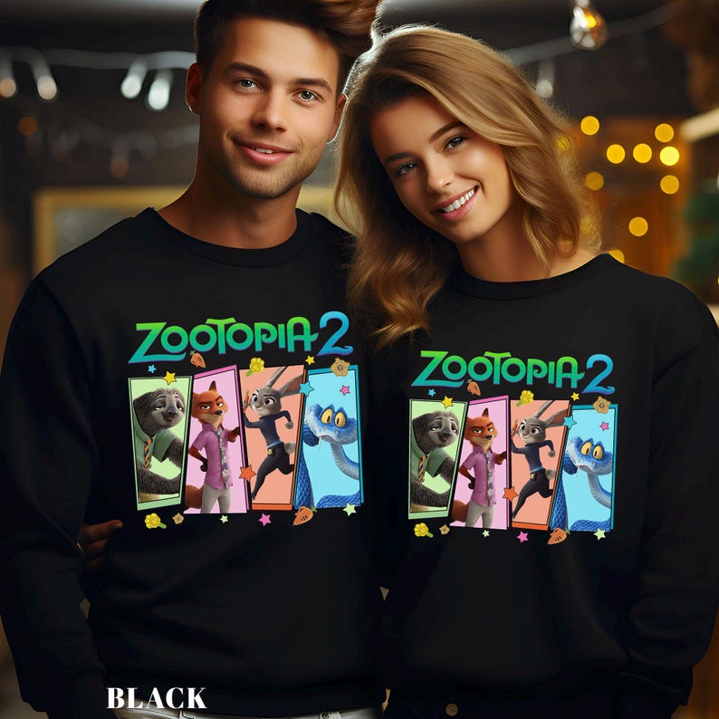 May include: Black sweatshirts featuring the text "Zootopia 2" above a colorful graphic of characters from the animated film. The graphic includes a sloth, fox, rabbit, and snake. The word "BLACK" is printed at the bottom.