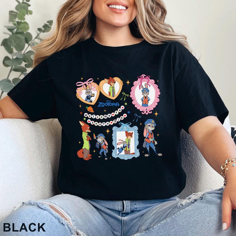 Pode incluir: Camiseta preta com um design de desenho animado colorido com personagens do filme Zootopia. O design inclui retratos emoldurados dos personagens, o t&iacute;tulo do filme e elementos decorativos. A palavra "BLACK" est&aacute; impressa na parte inferior.