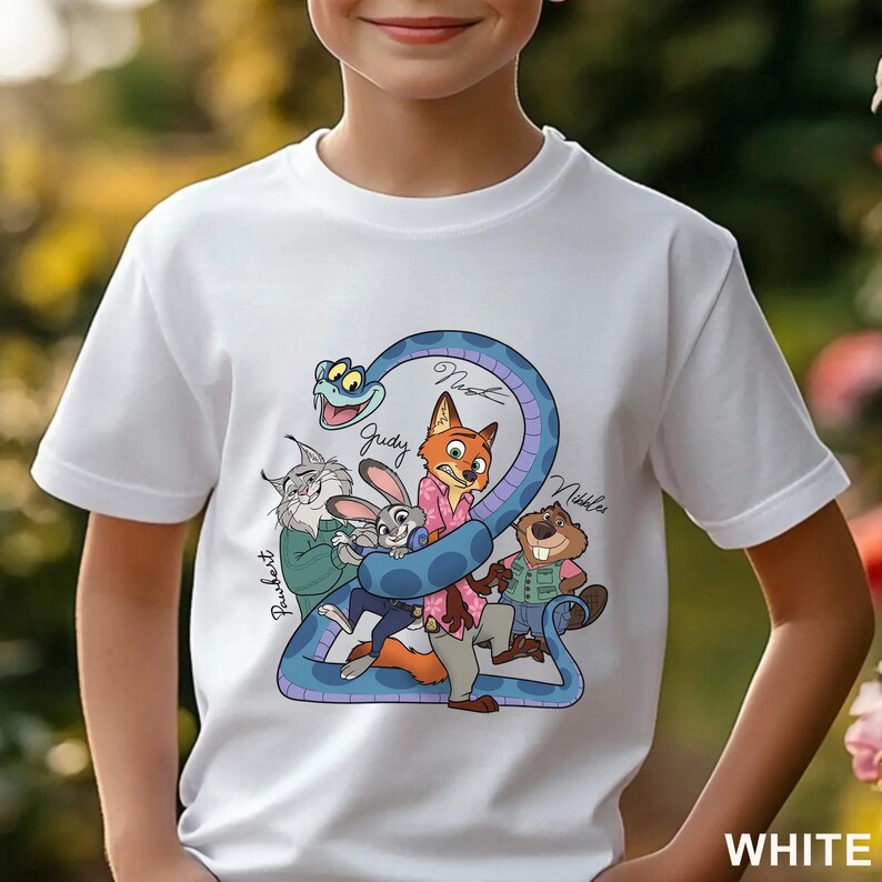 Puede incluir: Una camiseta blanca de manga corta con un gr&aacute;fico colorido de animales de dibujos animados, incluyendo un zorro, un conejo, un lince, un castor y una serpiente azul. Los nombres Judy, Nick, Nibbles y Pawbert est&aacute;n escritos en cursiva.