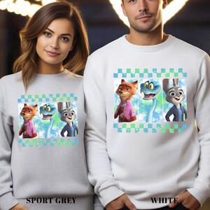 May include: Grey and white sweatshirts with a cartoon design of Nick Wilde, a snake, and Judy Hopps from Zootopia. The design is framed by a blue and green checkered pattern. The text "SPORT GREY" and "WHITE" are at the bottom.
