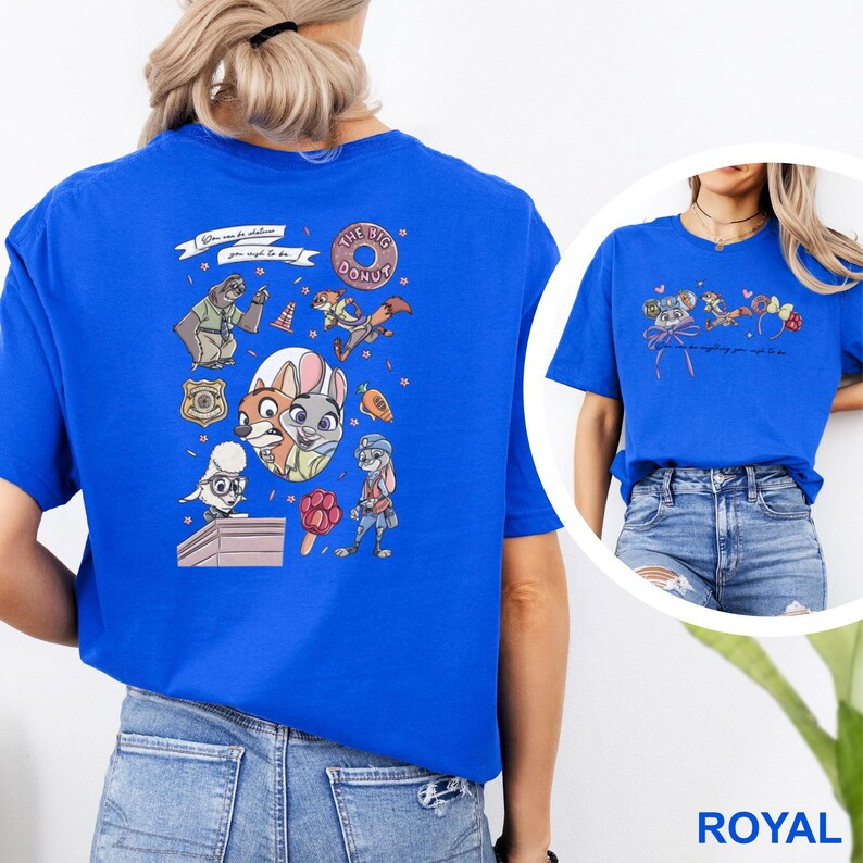 May include: A royal blue t-shirt featuring a large graphic on the back with various Zootopia characters, including a sloth, a fox, and a rabbit, alongside a donut and text. The front chest area displays a smaller graphic with mouse ears and text.