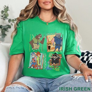 May include: Green t-shirt with a Zootopia cartoon design. The design features Flash the sloth, Nick Wilde, Judy Hopps, and other characters in colourful squares. The text "IRISH GREEN" is at the bottom of the shirt.