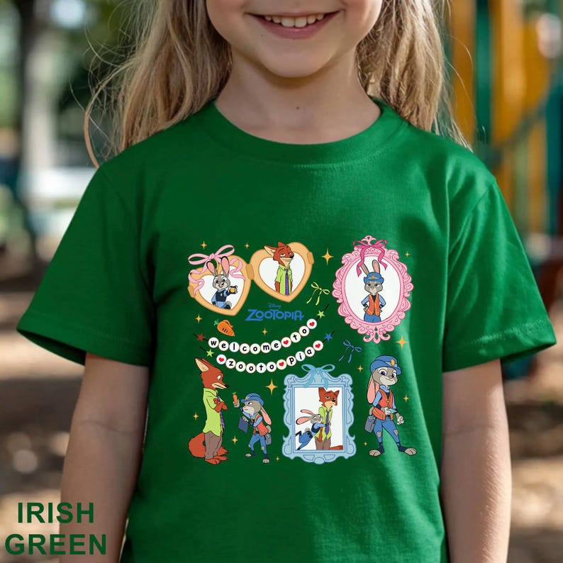 Pode incluir: Camiseta verde irland&ecirc;s com personagens de desenhos animados de Zootopia. O design inclui imagens emolduradas de Judy Hopps e Nick Wilde, junto com a palavra "Zootopia". A camiseta &eacute; feita de um material macio.
