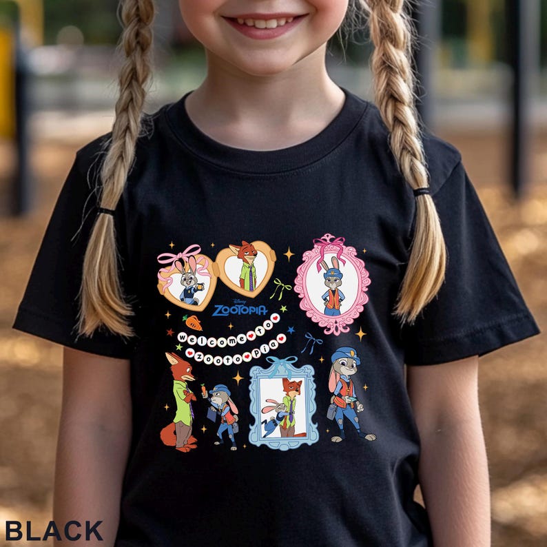 Pode incluir: Camiseta preta com imagens de desenhos animados de personagens do filme da Disney Zootopia. A camisa apresenta imagens emolduradas de Nick Wilde e Judy Hopps. A palavra "Zootopia" tamb&eacute;m &eacute; vis&iacute;vel na camisa.