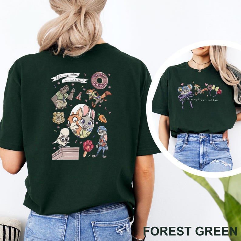 May include: A forest green short-sleeve t-shirt featuring Zootopia character graphics on the back and front. The back displays a collage of characters, a donut, a badge, and a carrot. The front shows small character icons and mouse ears.