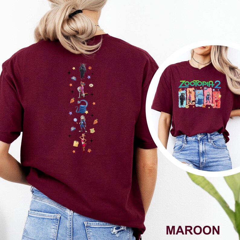 May include: Maroon t-shirt featuring a colorful graphic from Zootopia 2 on the front and a vertical design of characters on the back. The shirt is a solid maroon color and has short sleeves.