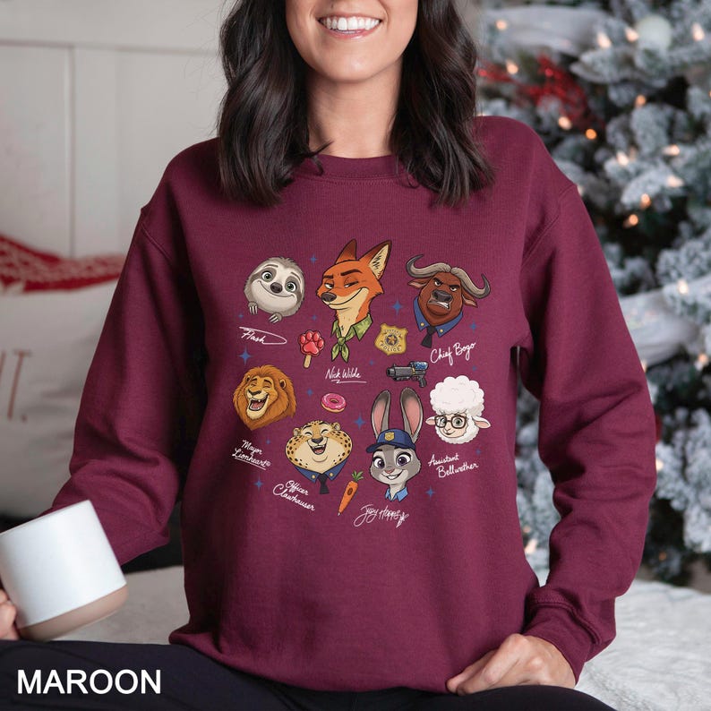 May include: Maroon sweatshirt featuring cartoon characters from a movie. The design includes a sloth, fox, lion, cheetah, bunny, and other characters. The word "MAROON" is printed at the bottom of the sweatshirt.