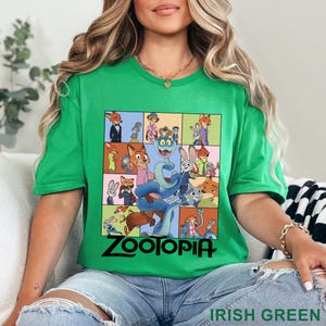 May include: A bright green short-sleeve t-shirt featuring a grid of various cartoon characters from the movie Zootopia, including a large blue snake in the centre. The word Zootopia is printed in black text at the bottom of the graphic design.