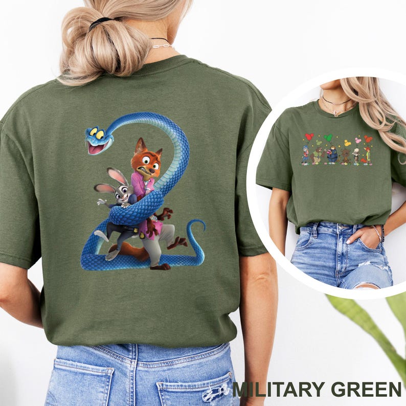 K&ouml;nnte beinhalten: Milit&auml;rgr&uuml;nes T-Shirt mit einer Cartoon-Illustration eines Fuchses, eines Kaninchens und einer blauen Schlange. Der Fuchs tr&auml;gt eine rosa Jacke, das Kaninchen eine blaue. Ein kleineres Bild von Cartoon-Charakteren ist ebenfalls zu sehen.