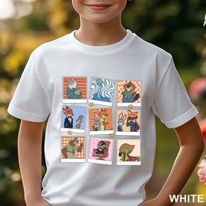 Pode incluir: Camiseta branca com uma grade de retratos de personagens de desenhos animados. Cada retrato &eacute; emoldurado em estilo polaroid. Os personagens est&atilde;o em v&aacute;rias poses e roupas. A palavra "WHITE" &eacute; impressa em branco no canto inferior direito.