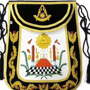 May include: A black velvet Masonic apron with gold trim and embroidered symbols, including a compass and square, an all-seeing eye, and a checkered floor.
