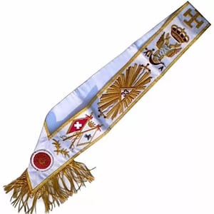 May include: White sash with gold embroidery, featuring a crown, a winged eagle, a compass and square, a sunburst, and a red cross. The sash has a gold fringe.