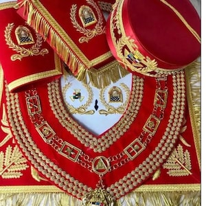Könnte beinhalten: Roter und goldener Freimaurer-Kragen mit einem Anhänger in Form eines Sterns und eines Dreiecks. Der Kragen hat einen Fransenbesatz und ist mit goldenen Stickereien verziert.