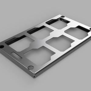 May include: A metallic gray SIM card tray with multiple cut-out sections. The rectangular tray has rounded corners and several circular holes. The design suggests a tech or electronics component.
