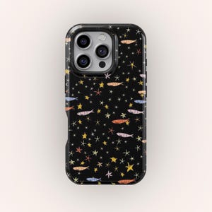 Può includere: Custodia per telefono nera con un motivo ripetuto di pesci e stelle colorate. I pesci sono in tonalità arancioni, blu e rosa, mentre le stelle sono gialle e bianche. La custodia ha una finitura lucida.