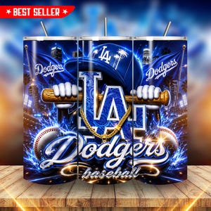 Puede incluir: Un vaso cilíndrico con temática de béisbol azul de los Los Angeles Dodgers que incluye una gorra, un bate de béisbol, una cadena dorada y una pelota. El diseño presenta el logotipo de los Dodgers, el texto Dodgers y la palabra baseball.