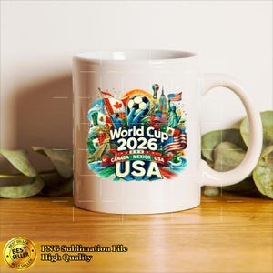 May include: White ceramic mug featuring a colorful design for the 2026 World Cup, with flags of Canada, Mexico, and the USA. The design includes a soccer ball, the Statue of Liberty, and the text "World Cup 2026 USA".