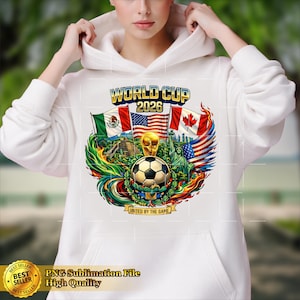 May include: White hoodie featuring a colorful graphic for the 2026 World Cup. The design includes a soccer ball, flags of Mexico, the United States, and Canada, and the text "WORLD CUP 2026". The phrase "UNITED BY THE GAME" is also present.