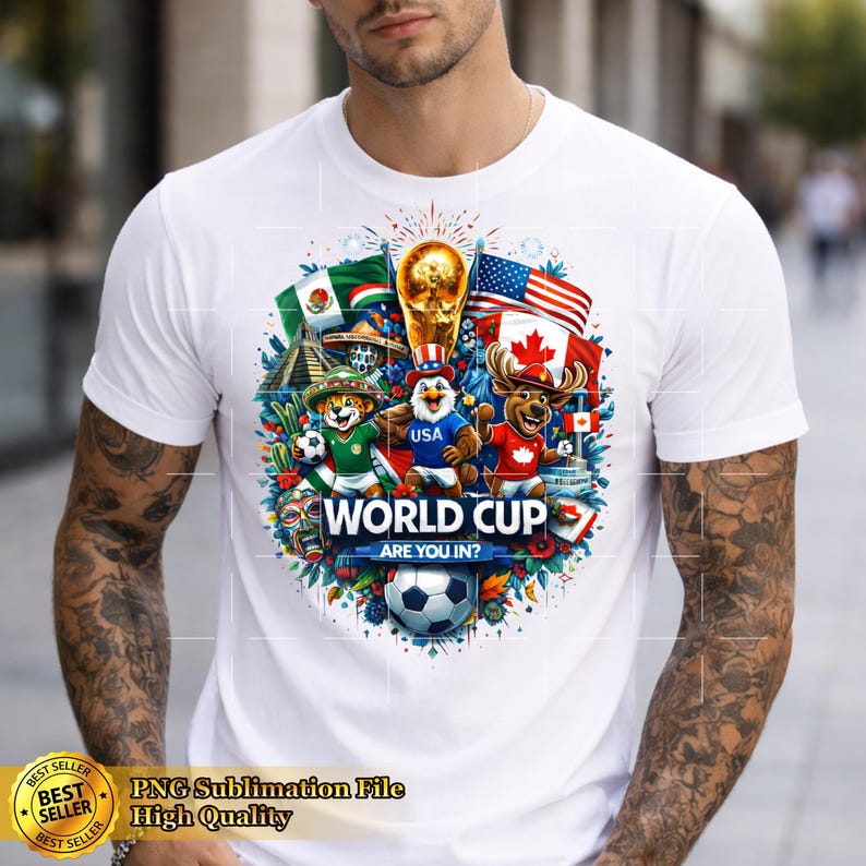 May include: White t-shirt featuring a colorful World Cup design. The graphic includes flags of the USA, Mexico, and Canada, along with cartoon characters and a soccer ball. Text reads "WORLD CUP ARE YOU IN?"