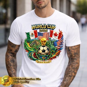 May include: White t-shirt featuring a colorful graphic for the 2026 World Cup. The design includes flags of Mexico, the United States, and Canada, a soccer ball, and the text "WORLD CUP 2026". The shirt also has the text "UNITED BY THE GAME".