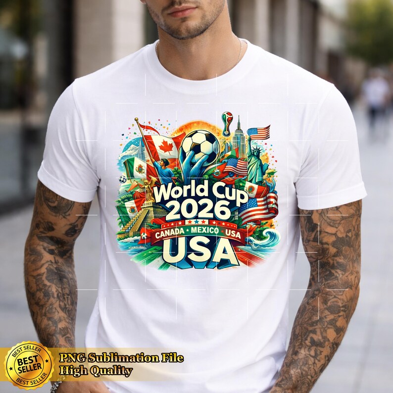 May include: White t-shirt featuring a colorful graphic for the 2026 World Cup, with flags of Canada, Mexico, and the USA. The design includes a soccer ball and the text "World Cup 2026 CANADA MEXICO USA USA".