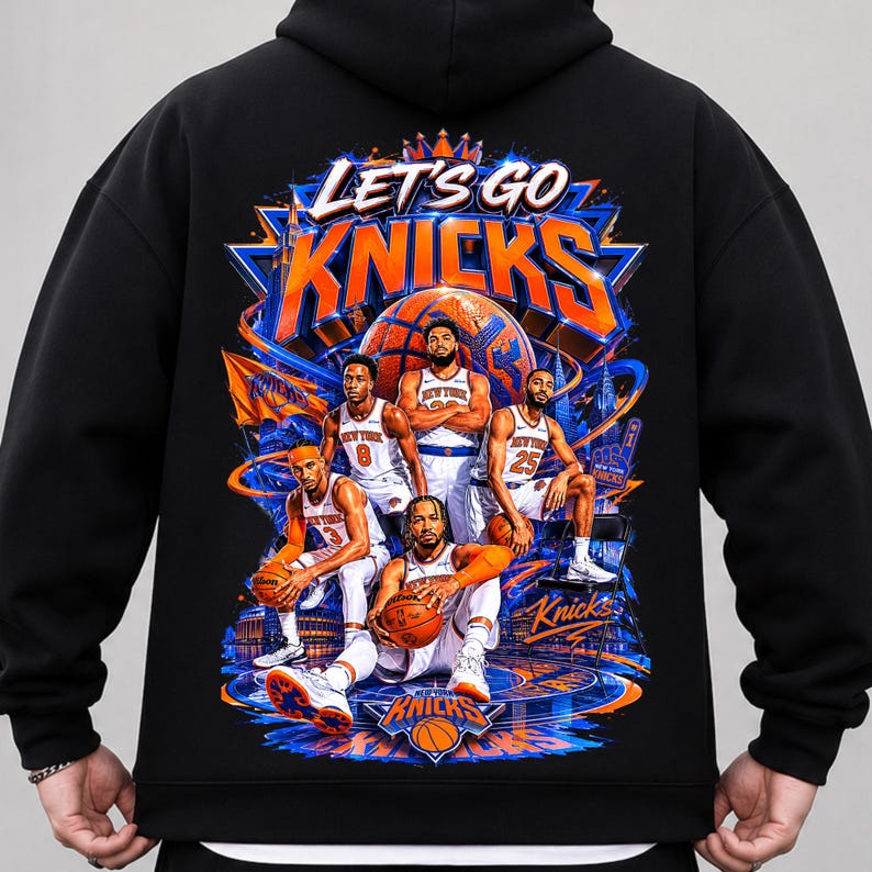 May include: Black hoodie featuring a vibrant graphic of the New York Knicks basketball team. The design includes the words "LET'S GO KNICKS" in orange and blue, along with illustrations of players and a basketball court.