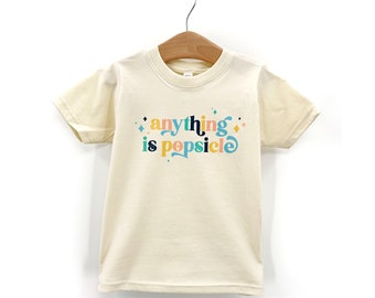 May include: A cream colored short-sleeved t-shirt with the text "anything is popsicle" in colorful letters.