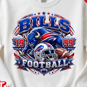 Pode incluir: Uma camisola branca de gola redonda com uma impressão gráfica de um bisão azul, um capacete de futebol americano e uma bola. O texto diz BILLS, FOOTBALL, EST. 1959. O design inclui cores vermelha, branca e azul com estrelas num padrão circular.
