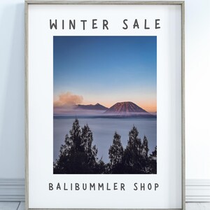 Könnte beinhalten: Ein gerahmter Druck mit einer Bergkette und einem See im Vordergrund. Der Druck hat den Text "WINTER SALE" oben und "BALIBUMMLER SHOP" unten.
