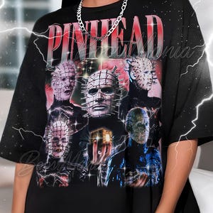 May include: Black oversized t-shirt featuring a graphic of the word "PINHEAD" in red, with multiple images of the character from the horror film. The design includes images of the character's face and body. A silver chain necklace is visible.