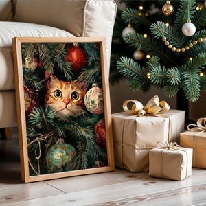 May include: A framed print featuring a ginger cat peeking through a Christmas tree, surrounded by ornaments. The cat has large, expressive eyes. The print is in a wooden frame, with a Christmas tree and wrapped gifts in the background.