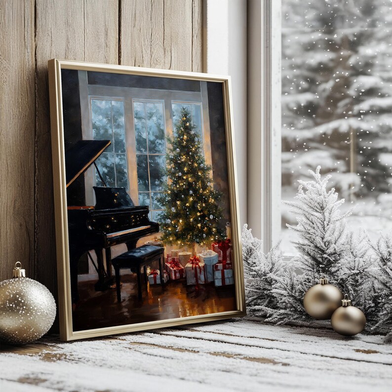 May include: A framed painting depicts a Christmas scene with a grand piano, a decorated Christmas tree, and wrapped gifts. The painting is in a gold frame, set against a snowy window background. Ornaments and frosted miniature trees are in the foreground.