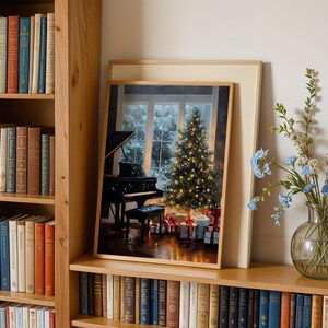 May include: A framed print depicts a Christmas scene with a decorated tree, gifts, and a grand piano. The print is displayed on a wooden shelf with a vase of blue flowers. Bookshelves filled with books are on either side.