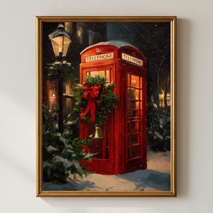 May include: A framed painting depicts a red telephone booth adorned with a Christmas wreath and bow, set against a snowy backdrop. The words "TELEPHONE" are visible on the booth. A lamppost and evergreen trees are also present.