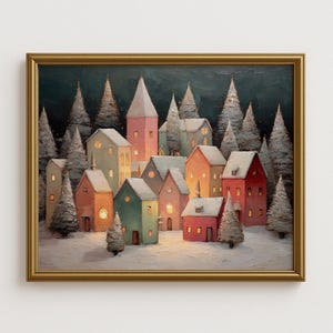Puede incluir: Pintura enmarcada que representa una escena de un pueblo invernal. Casas coloridas con tejados nevados se encuentran entre árboles de hoja perenne cubiertos de nieve. La obra de arte presenta un marco dorado y un cielo oscuro y estrellado, creando un ambiente acogedor y festivo.