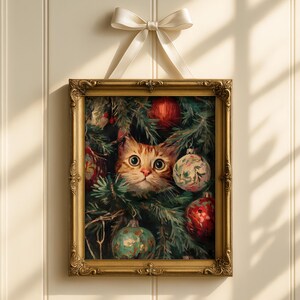 May include: Framed artwork featuring a ginger cat peeking through a Christmas tree adorned with ornaments. The painting is in a gold ornate frame, suspended by a white ribbon. The cat has large, expressive eyes, and the ornaments are red and green.