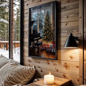 May include: A framed print depicts a Christmas scene with a piano, decorated tree, and wrapped gifts. The print hangs on a wood-paneled wall next to a black sconce. A lit candle sits on a wooden table near a window overlooking a snowy forest.