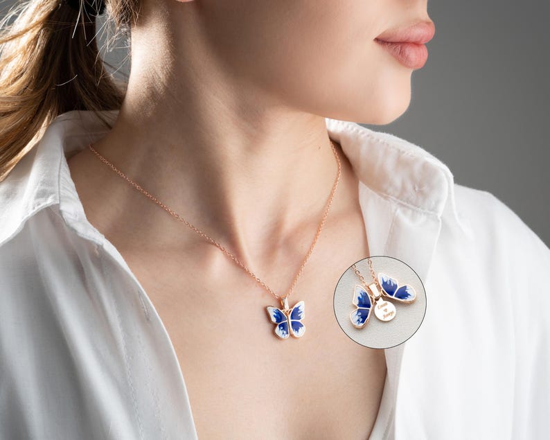May include: A delicate gold chain necklace with a blue and white enamel butterfly pendant. The butterfly has a detailed design and is a beautiful piece of jewellery.