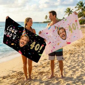 Könnte beinhalten: Zwei Strandtücher, eines schwarz und eines rosa, jeweils mit einem Ausschnitt für ein Gesicht. Auf dem schwarzen Handtuch steht "LOOK WHO'S 40!" mit Konfetti. Auf dem rosa Handtuch steht "LOOK WHO'S 40!" mit Konfetti. Beide Tücher zeigen das Gesicht eines Mannes.