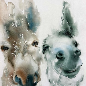 May include: Watercolour painting of two donkeys. The donkey on the left has brown and grey tones, with a blue accent on its ear. The donkey on the right is grey and white, with a smiling expression. The artwork is on a white background.