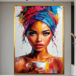 May include: A colourful portrait painting of a woman with blue eyes and a vibrant head wrap, holding a white teacup. The artwork features bold brushstrokes and a gold frame. The painting is displayed in a modern interior setting.