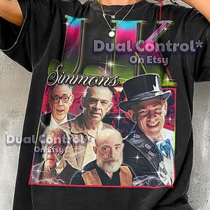May include: Black t-shirt featuring a vintage-style graphic of a group of men with the text "UK Simmons" and "Dual Control On Etsy". The graphic has a red border and a distressed look.