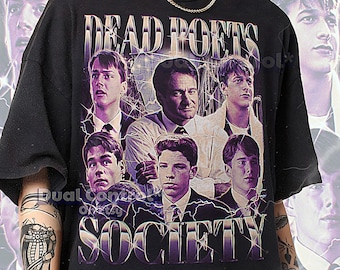 May include: Black unisex t-shirt featuring a graphic of the movie "Dead Poets Society" with the text "Dead Poets Society" in a purple font. The shirt has a crew neck and short sleeves. The shirt is made of a soft material.