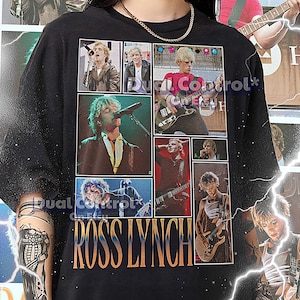 May include: Black t-shirt with a collage of images of Ross Lynch, a singer and actor, performing on stage. The images are arranged in a grid pattern and include photos of him playing guitar, singing into a microphone, and posing with his bandmates. The text "ROSS LYNCH" is printed in large, yellow letters at the bottom of the shirt.