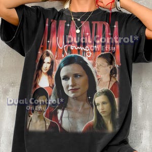 Könnte beinhalten: Schwarzes T-Shirt mit einem roten Aufdruck des Namens "AMANDA" und dem Namen "Young" in einer Schriftart. Das Shirt zeigt auch mehrere Bilder einer Frau in roter Kleidung.
