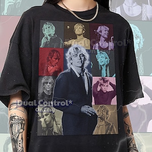 May include: Black unisex t-shirt featuring a grid of nine images of a person. The central image is a close-up of the person. The shirt has the text "Dual Control* on Etsy" and sizing information.